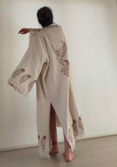 Elevate your style with our Beige Kimono Robe, beautifully adorned with elegant bird and feather embroidery. This boho chic long kimono is designed for women who appreciate a blend of style and comfort. Made from lightweight and breathable fabric, it's perfect for lounging at home, adding a stylish layer to your summer outfits, or as a chic cover-up for yoga sessions. The intricate bird and feather embroidery adds a touch of nature-inspired elegance, while the fringe details enhance its bohemian White Long-sleeve Kaftan With Woven Motifs, White Long Sleeve Kaftan With Woven Motifs, Beige Embroidered Kimono With Kimono Sleeves, Beige Embroidered Long Sleeve Kimono, Beige Long Sleeve Cotton Kaftan, Traditional Beige Cotton Kimono, Spring Beige Cotton Kaftan, Beige Cotton Kaftan For Spring, Long Embroidered Cotton Kimono