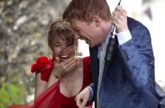 a man and woman laughing in the rain