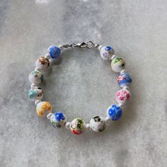 Lovely floral bead bracelet made with porcelain ceramic beads and crystal pearls.  Each bead is multi color, different color / pattern, giving you the ability to wear it with so many outfits!  This flower bead bracelet is perfect alone or stacked with minimalist pieces.  The components are all stainless steel, naturally hypoallergenic and corrosion resistant.  This bracelet is made to last!  10mm porcelain beads.  The total length of the bracelet is 7 3/4", and fits like a standard 7" (medium) b Floral Bead Bracelet, Flower Bead Bracelet, Flower Beaded Bracelet, Ceramic Beads Bracelet, Porcelain Beads, Bracelet Pearl, Floral Bracelet, Porcelain Flowers, Jewelry Studio