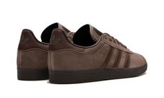 The adidas Gazelle “Earth Strata/Brown” is an all-brown colorway of the retro sneaker.  The popular silhouette by the German footwear company features a brown suede construction with slightly darker brown leather Three Stripes branding on each side of the shoe.  Gold “Gazelle” detailing appears on the lateral side of the mid-panel, while an adidas Trefoil logo is printed tonally on the brown leather heel tab.  A debossed adidas Trefoil logo can be seen on the brown tongue.  Underfoot, a dark brown rubber sole completes the look. Adidas Shoes Gazelle, Gum Shoes, Stripes Branding, Adidas Ad, Brown Leather Sneakers, Brown Leather Heels, Adidas Trefoil, Stadium Goods, Retro Sneakers