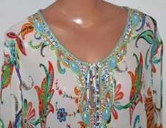 Multicolor V-neck Blouse With Embroidered Neckline, Embellished Multicolor V-neck Tops, Multicolor Beaded Tops For Festival, Multicolor Embroidered Neckline Blouse For Beach, Multicolor Embroidered Neckline Blouse For The Beach, Beach Blouse With Embroidered Neckline In Multicolor, Spring Beaded Multicolor Tops, Multicolor Beaded Bohemian Tops, Tunic Blouse