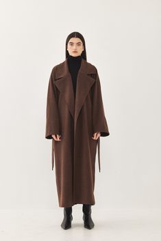 A heavy weight longline rode coat. An oversize fit with long voluminous sleeves and side pockets. Features a lapel collar with an embroidered logo. Comes with a detachable waist belt. A cozy worm coat you can wear over any outfit. 100% Polyester Color: Brown Care: Dry clean only Oversize fit, take your usual size. Model wears: M Model's fit:1.75 cm Waist 59 cm Hips 86 cm Bust 78 cm How to measure yourself Long Wool Coat Women, Voluminous Sleeves, Wool Coat Women, Long Wool Coat, Long Trench Coat, Oversized Coat, Brown Coat, Brown Jacket, Model Fits