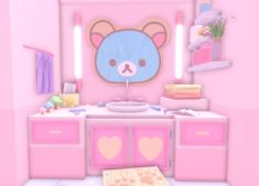 a pink bathroom with a blue teddy bear on the wall and other items in front of it