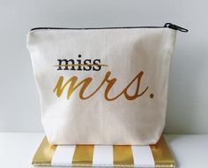 a white and gold striped bag with the word miss mrs on it's side