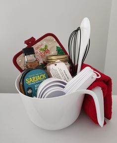 a white bowl with utensils in it sitting on a table