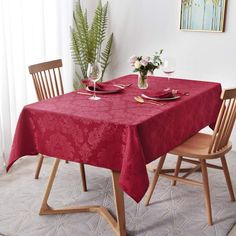 a red table cloth on top of a wooden chair next to a potted plant