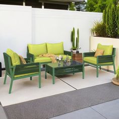 an outdoor patio with green furniture and potted plants