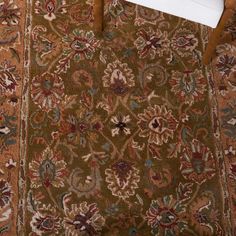 a chair sitting on top of a rug next to a wooden table with an open book