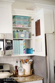 a kitchen with white cupboards and appliances inside of it, including a refrigerator freezer