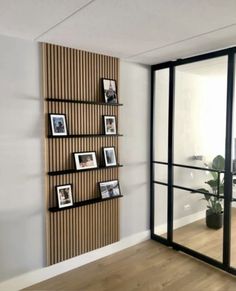 an empty room with pictures on the wall and a large glass door leading to another room