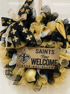 a new orleans saints wreath is hanging on the door to welcome you for your team