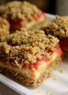 two pieces of dessert sitting on top of a white plate with crumb toppings