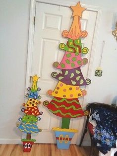 a christmas tree made out of cardboard sitting in front of a door with decorations on it