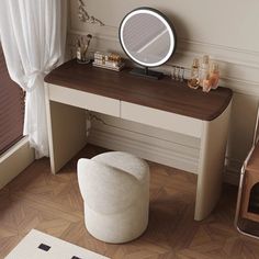 a dressing table with a mirror and stool in a small room next to a window