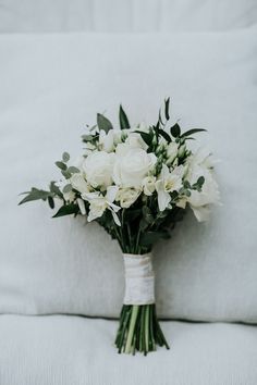 a bouquet of white flowers sitting on top of a bed