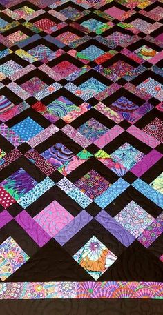 a colorful quilt is displayed on a table