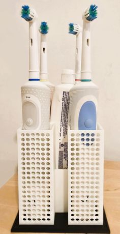 three toothbrushes sitting on top of each other in front of two air freshener dispensers