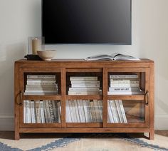 an entertainment center with books on it and a flat screen tv