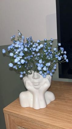 a vase filled with blue flowers sitting on top of a wooden table