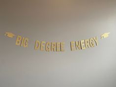 a banner that says, big degree energy hanging from the wall in front of a desk