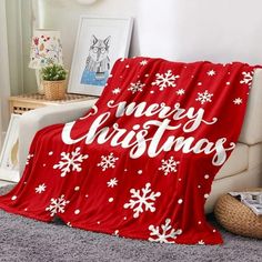 a red christmas blanket sitting on top of a couch