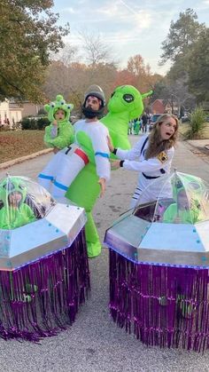 two people dressed in costumes standing next to each other on the street with purple fringes