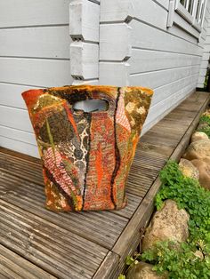 an orange and brown bag sitting on top of a wooden deck next to a building