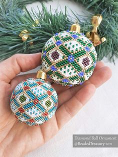 someone is holding two ornaments in their hand