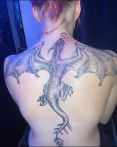 a woman with a dragon tattoo on her back