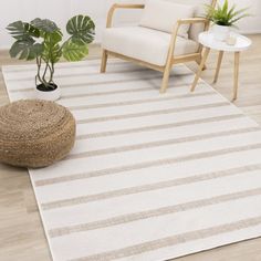 a living room area with a chair, rug and potted plant on the floor