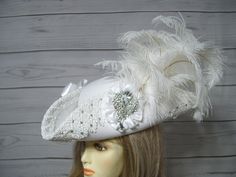 "Beautiful made to order white woolen wedding pirate hat with handsewn white Venise lace around the brim with hand placed glass rhinestones that sparkly in the light, two white satin bows, white satin cocarde with a large sparkly jewel and a waterfall of white ostrich feathers. This hat is so pretty and was a labor of love. Perfect for a pirate themed wedding. The brim of the hat is 4\" folded up. This is not an oversized pirate hat. This hat is 22.5\" for the inside circumference. This hat has a built-in hat adjuster, just cinch and tie for a tighter fit. I cannot make the circumference bigger so please keep that in mind. Please measure your head before ordering as I do not take returns as all sales are final. Check out my other pirate hats and other goodies in my etsy shop. Thank you for Handmade White Wedding Costume Hats And Headpieces, White Handmade Wedding Costume Hats And Headpieces, Handmade White Wedding Headpieces, Handmade White Mini Hats For Wedding, Handmade White Wedding Hat, Steampunk Pirate Female, Musketeer Costume, Tricorn Hat, Sea Fashion