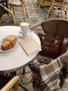 a table with a plate of food and a cup of coffee sitting on top of it