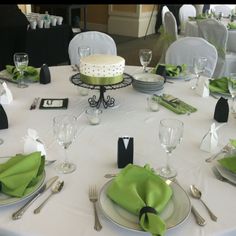 the table is set with green napkins and silverware for an elegant wedding reception