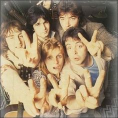 a group of people making the peace sign with their hands