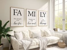 a living room filled with white furniture and two framed pictures on the wall above it