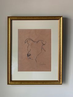 a framed drawing of a dog's head on a wall