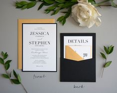 the wedding stationery is laid out with flowers and greenery