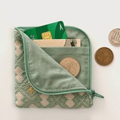 there is a wallet with money in it next to a coin and some other items