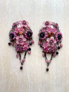 Spectacular Vintage Colleen Toland Fuchsia( bright and deep pink) and Black Beaded Floral Earrings.  These earrings are clip-on.  They are handbeaded with hand painted resin flowers and glass beads and metal roses.  There is a cluster of flowers that hug the ear complimented by a simple vee drop. The colors are striking and the style is elegant. These earrings were made in the early 2000s. The works shown in this shop are vintage Colleen Toland from past collections and they are the last of thes Elegant Pink Chandelier Earrings, Pink Beaded Chandelier Earrings For Wedding, Pink Clip-on Jewelry For Evening, Pink Dangle Chandelier Earrings, Handmade Pink Evening Earrings, Pink Drop Chandelier Earrings For Evening, Handmade Pink Earrings For Evening, Pink Dangle Chandelier Earrings For Evening, Pink Chandelier Drop Earrings For Evening