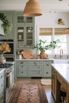 a kitchen with lots of green cabinets and white counter tops, along with a rug on the floor