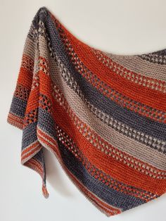 an orange and grey striped blanket on a white surface with the top half folded up