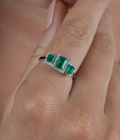 "3 Emerald cut natural Colombian Emeralds paired together in a vintage 18k white gold setting and adorned with 0.19 carats of round cut diamonds.  - Gold Karat: 18K  - 3 Emeralds: 1.03 carat total weight  - Round Diamond: 44 pieces, 1 MM, 0.19 carats  - Emerald origin: Muzo mine, Colombia - Ring Size: 7 1/2 U.S.  SHIPPING TIMES USA: 1-4 business days (USPS) Canada: 5-6 business days Australia: 5-12 business days (Australia Line) New Zealand: 7-20 business days Europe: 5-14 business days Other co Elegant Three-stone Emerald Diamond Ring, Elegant Three Stone Emerald Diamond Ring, Fine Jewelry 14k White Gold Three Stone Ring, Elegant Three Stone Emerald Ring In White Gold, 14k White Gold Three Stone Ring Fine Jewelry, 14k White Gold Three Stone Jewelry, 14k White Gold Three-stone Jewelry, 14k White Gold Three Stone Ring, White Gold Emerald Diamond Ring With Three Stones