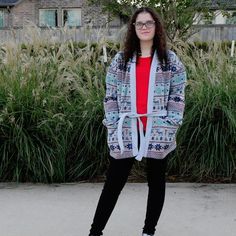 a woman standing in front of some tall grass and bushes with her feet on a skateboard