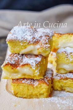 four pieces of cake sitting on top of a wooden cutting board covered in powdered sugar