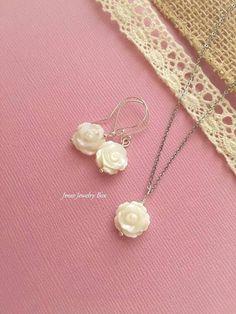 Lovey set of rose earrings and necklace. Little 12mm shell roses are double sided and sparkle in the light. Necklace Beautiful white shell rose necklace. Lovely little rose is 12mm wide. The rose is double sided and on an 18'' stainless steel chain with lobster clasp. Earrings Gorgeous white shell rose earrings, Very elegant little roses are 12mm and double sided. The total earring length is just over 1 inch. Hooks are silver plated brass. Like Jmesjewelrybox on Facebook for updates on new jewel Mother Of Pearl Rose, Rose Earring, Earring And Necklace Set, Rose Necklace, Rose Jewelry, Earrings White, Cute Necklace, Dream Board, Rose Earrings