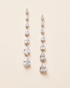 A minimalist design with lots of sparkle, our Celine Statement Earrings are expertly made with cascading sizes of pear shaped cubic zirconias. The long dangle style is light and easy to wear, making them perfect for weddings or any special occasion. Cubic zirconia Measures 2.5" in length Hypoallergenic, lead-free & nickel-free Style #4387 Pearl Earrings Hoop, Crystal Tiara, Silver Statement Earrings, Luxury Earrings, Crystal Tiaras, Pearl Crystal, Shop Wedding, Cz Earrings, Pearl Stud Earrings