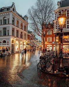 people are walking down the street at night with their bikes parked in front of them