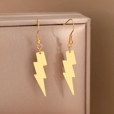 Gold Lightning Bolt Charm Dangle Earrings Trendy Gold Metal Earrings, Trendy Yellow Gold Metal Earrings, Trendy Gold-tone Pierced Earrings, Trendy Matte Gold Metal Earrings, Trendy Gold-tone Brass Earrings, Trendy Gold-tone Dangle Earrings, Trendy Gold Linear Earrings, Trendy Gold Dangle Linear Earrings, Trendy Gold Linear Earrings With Ear Wire