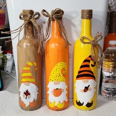 three painted wine bottles sitting next to each other