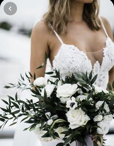 a woman holding a bouquet of white flowers